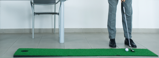 A man playing mini golf in his office